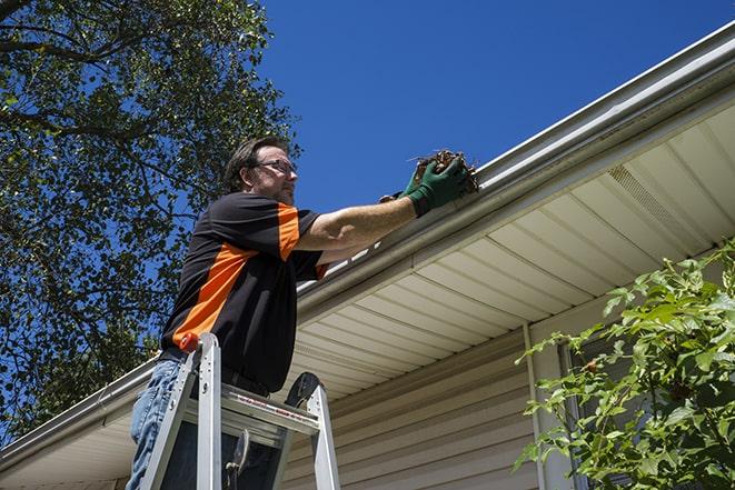 a repair team working on a residential gutter in Brooklyn Center